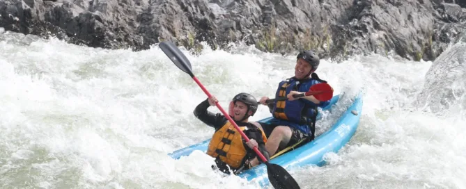 two people enjoying Kayaking with waves